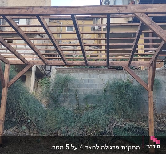 פרגולה מעץ בגינה עם קורות עץ חומות